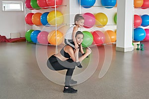 Fitness mother and child. Sports activities with children. Fitness center. Mom and baby gymnastics, yoga exercises. Health and