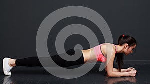 Fitness and motivation - slim athletic woman doing the planck.