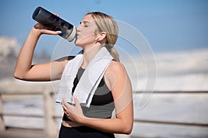 Fitness, music and woman drinking water at the beach for sports, running and cardio routine. Podcast, bottle and thirsty