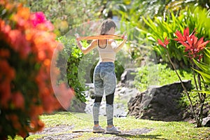 Fitness outdoor workout with resistance band. Young fit woman doing back and arms exercise.