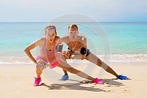 Fitness pals streching after workout on the beach