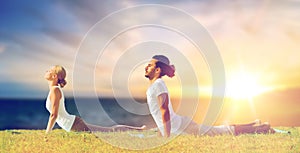 Couple making yoga cobra pose outdoors