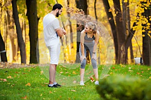 Fitness. Personal Trainer Takes Notes While Woman Exercising Outdoor