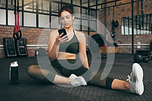 Fitness, phone and woman at gym for a workout, training and body wellness with a mobile app. Young sports female with