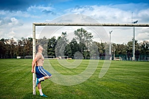 Fitness player working out on football field. Cross fit training outdoors on a summer day.