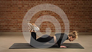 Fitness practitioner perfecting knee push-ups to enhance muscular endurance, brick wall gym