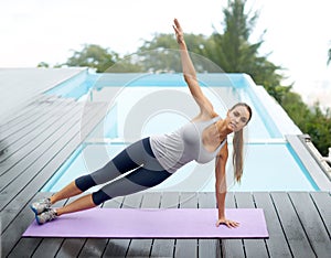 Fitness, relax and pool deck with balance, yoga mat and exercise by water with side plank outdoor at home. Wellness