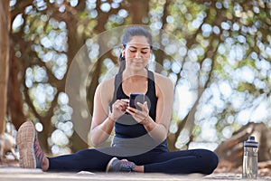 Fitness, relax and woman in park with phone on break after running, exercise and workout in nature. Sports, wellness and