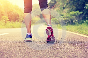 Fitness runner woman legs walking on trail