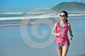 Fitness and running on beach, happy woman runner jogging on sand near sea, healthy lifestyle and sport