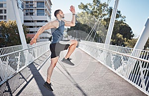 Fitness, running and exercise with a sports man on a bridge in the city for a cardio or endurance workout. Health