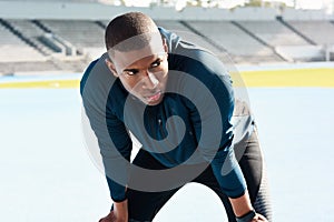 Fitness, running and tired with sports black man in stadium venue for competition or performance. Exercise, fatigue and