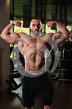 Fitness Shaped Muscle Man Posing In Dark Gym