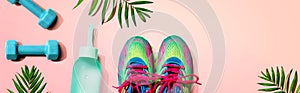 Fitness shoes and dumbbells with tropical plants