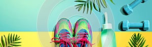 Fitness shoes and dumbbells with tropical plants