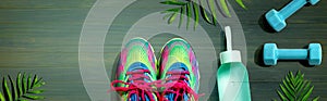 Fitness shoes and dumbbells with tropical plants