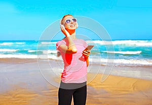 Fitness smiling woman listens to music in wireless headphones