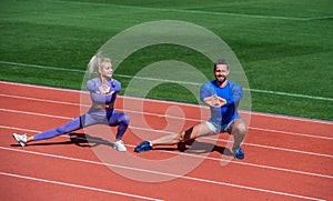 Fitness sport couple warming up and stretching together on outdoor stadium racetrack wearing sportswear, workout