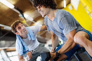 Fitness, sport, exercising concept. Fit man exercising together with his personal trainer in gym.