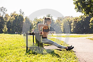 Fitness, sport, exercising, training and people concept - couple doing triceps dip exercise on city street bench.