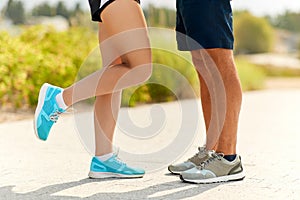 Legs of couple of sportsmen in sneakers outdoors