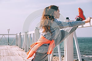 Fitness sport girl in fashion sportswear doing yoga fitness exercise in the street by sea