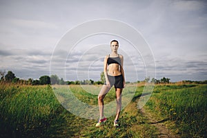 Fitness sport girl runner taking break after jogging outdoors