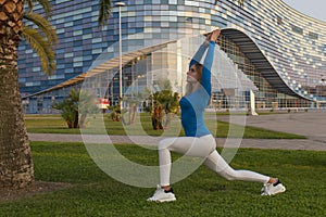 Fitness sport girl in sportswear doing fitness exercise in the street,outdoor sports. Sports girl in light clothing is