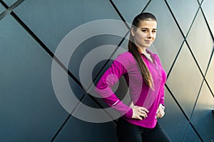 Fitness sport girl in sportswear doing yoga fitness exercise in the street on black wall, outdoor sports, urban style