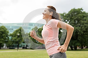 Woman with earphones running at park