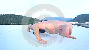 Fitness sport man doing clap push-ups outside on a rooftop
