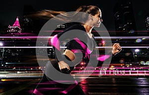 Fitness and sport motivation. Strong athletic woman sprinter, running in the night city. Girl model wearing sportswear