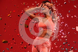 Fitness and sport motivation.. Strong and fit athletic, woman with tattoo posing on red background in sportswear.