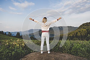 Fitness, sport, peope and emotions concept, happy woman in sportswear enjoying freedom over mountains and blue sky background. photo