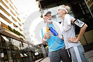 Fitness, sport, people, exercising and lifestyle concept - senior couple running