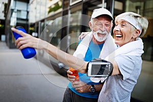 Fitness, sport, people, exercising and lifestyle concept - senior couple running