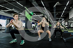 Fitness, sport, training, gym and lifestyle concept - group of smiling people exercising in the gym, doing squats