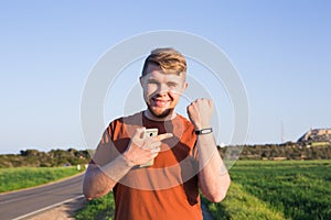 Fitness, sport, training and lifestyle concept - close up of young man with heart-rate watch bracelet in summer park.