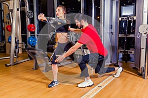 Fitness, sport, training and people concept - Personal trainer helping woman working with in gym