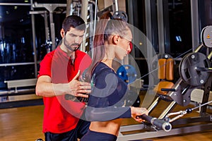 Fitness, sport, training and people concept - Personal trainer helping woman working with in gym