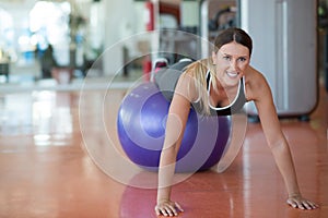 Fitness, sport, training and people concept - smiling woman flexing abdominal muscles with exercise ball in gym