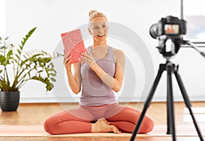 Woman with camera streaming for yoga blog at home