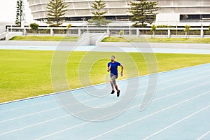 Fitness, sports man and running on race track for athletics, sprint challenge or competition training in stadium. Runner