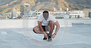 Fitness, sports shoes and athlete in the city preparing for a workout on a rooftop in Mexico. Wellness, health and man
