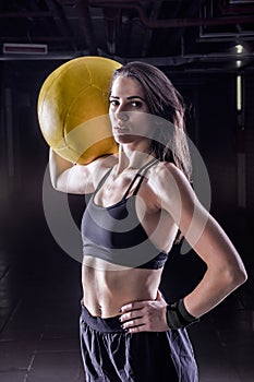 Fitness sports woman holding soft medicine ball indoors.