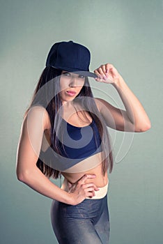 Fitness sporty cool girl wearing fashion sportswear. Brunette model with long dark hairs seriously looking at camera