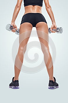 Fitness sporty woman in training pumping up muscles with dumbbells