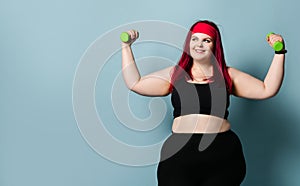 Fitness spring diet weight loss concept. Lucky plus-size girl overweight woman dieting working out with green weights dumbbells