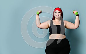 Fitness spring diet weight loss concept. Lucky plus-size girl overweight woman dieting working out with green weights dumbbells