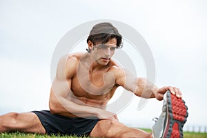 Fitness, stretching and man on grass for workout, summer sports and wellness in outdoor training. Exercise, warm up for